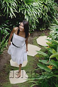 AsiaPix - Young woman walking in tropical garden