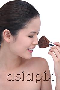 AsiaPix - Young woman using make-up brush
