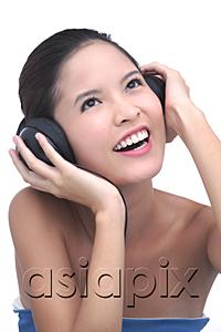 AsiaPix - Young woman listening to music, wearing headphones