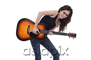 AsiaPix - Young woman playing guitar, studio shot