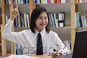 AsiaPix - Young woman in library, hand raised, smiling