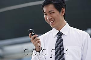 AsiaPix - Businessman looking at mobile phone, smiling