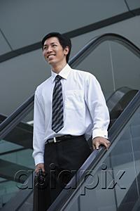 AsiaPix - Businessman on escalator, smiling