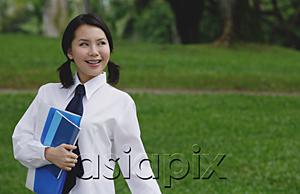 AsiaPix - Young woman in school uniform, standing in park, looking away