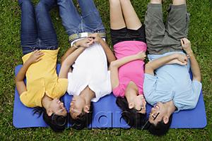 AsiaPix - Young adults in park, lying on mat