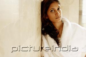 PictureIndia - Woman in bathrobe, leaning on wall, looking at camera