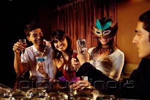 PictureIndia - Couples at bar, with drinks and mobile phone.