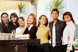 PictureIndia - Young adults standing at bar counter, in a row