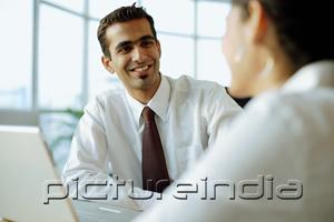 PictureIndia - Executive smiling at person in front of him