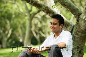 PictureIndia - Young man listening to music with headphones