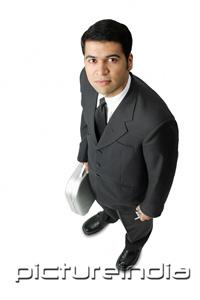 PictureIndia - Businessman, holding mobile phone and briefcase, looking up at camera