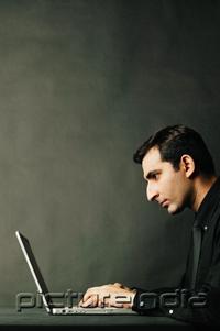 PictureIndia - Man using laptop, profile