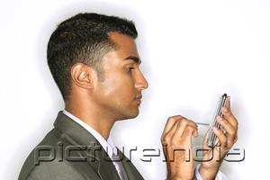 PictureIndia - Businessman using PDA, side view