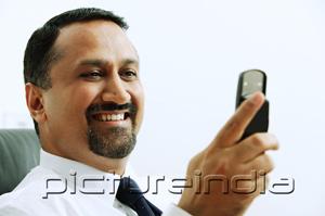 PictureIndia - Businessman looking at mobile phone