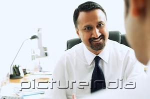 PictureIndia - Businessman smiling at person in front of him