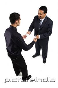 PictureIndia - Two businessmen standing and exchanging namecards