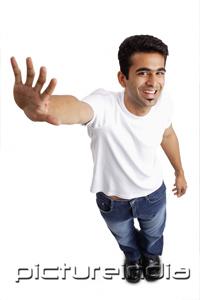 PictureIndia - Man smiling at camera, arm outstretched, showing palm