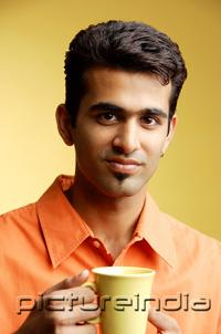PictureIndia - Man looking at camera, mug in hand
