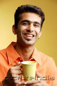 PictureIndia - Man smiling at camera, mug in hand