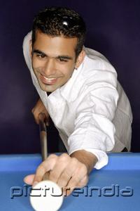PictureIndia - Young man aiming with pool cue