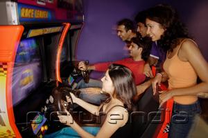 PictureIndia - Young adults playing games in amusement arcade
