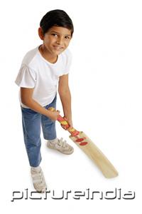 PictureIndia - Boy holding cricket bat, smiling at camera