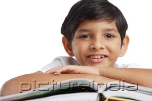 PictureIndia - Boy leaning on book, looking at camera