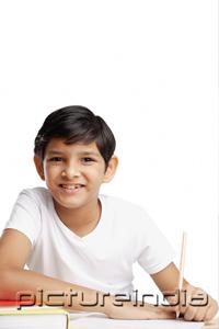 PictureIndia - Boy with book and pencil, looking at camera