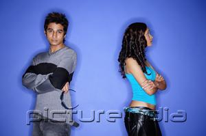 PictureIndia - Couple standing apart against blue wall
