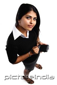 PictureIndia - Woman holding PDA, looking up at camera