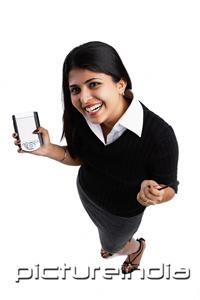 PictureIndia - Woman holding PDA, looking up at camera, high angle view