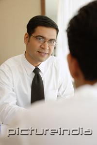PictureIndia - Businessman smiling at man opposite from him