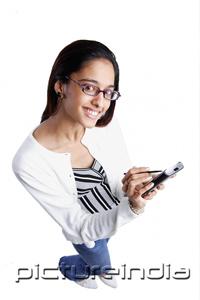 PictureIndia - Woman using PDA, smiling, high angle view