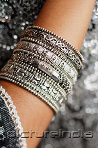 PictureIndia - Close-up of woman's arm with silver bangles