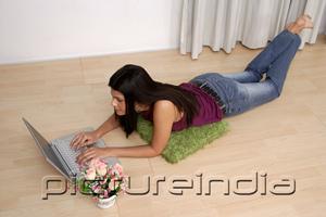 PictureIndia - Woman lying on floor, using laptop, high angle view