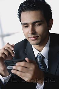 PictureIndia - Young businessman using mobile phone, text messaging