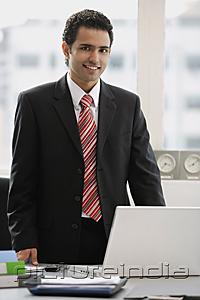 PictureIndia - Businessman standing in office, looking at camera
