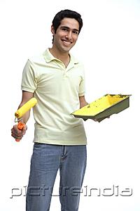 PictureIndia - Man holding paint roller and paint tray