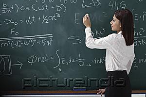 PictureIndia - Woman writing equations on chalk board
