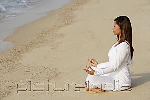 PictureIndia - woman practicing yoga at the beach