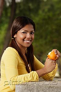 PictureIndia - woman peeling orange outside