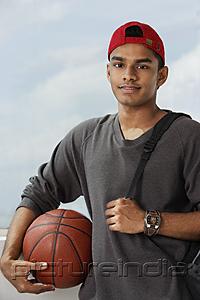 PictureIndia - young man with red cap holding basket ball and carrying backpack