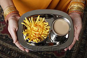 PictureIndia - tight shot of woman holding a tray with tea.