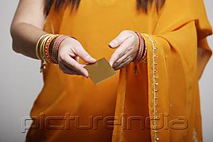 PictureIndia - Cropped shot of woman wearing sari, holding credit card