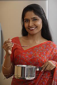 PictureIndia - Indian woman wearing sari while preparing food.