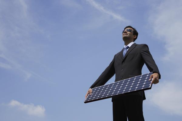 PictureIndia - Businessman holding solar panel.