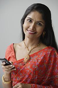 PictureIndia - Indian woman wearing a sari and using a mobile phone