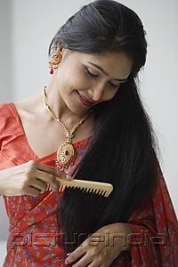 PictureIndia - Indian woman wearing a sari and combing her hair
