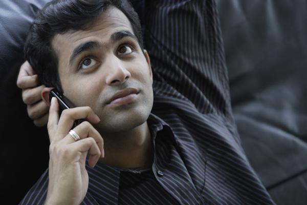 PictureIndia - Indian businessman looking up while talking on phone.