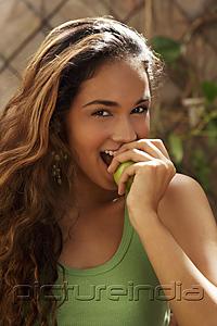 PictureIndia - Young woman biting green apple